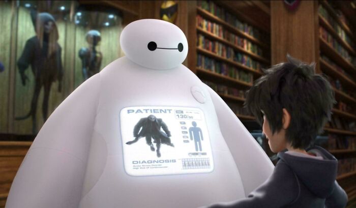 Animated robot displaying a patient diagnosis screen while interacting with a young boy in a detailed library setting.