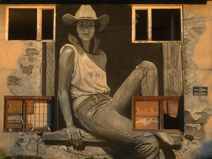 Mural of a woman in a cowboy hat painted on a wall, showcasing impressive DIY wins and creative street art skills.