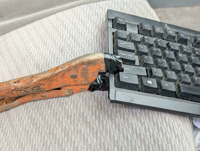 Rusty pliers duct-taped to a damaged keyboard, a redneck engineering example that might shock actual engineers.
