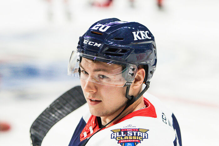 Curtis Lazar in hockey gear during a game, wearing a helmet and jersey with All-Star Classic patch visible.