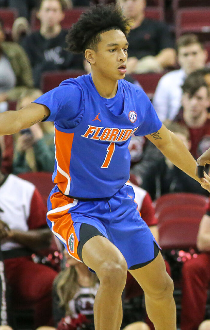 Tre Mann in a Florida basketball uniform, actively playing defense during a college basketball game.