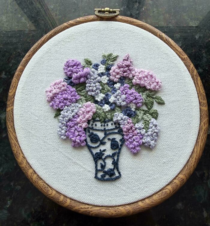 A beautiful embroidery creation depicting a vase filled with colorful flowers, ideal for embroidery enthusiasts.
