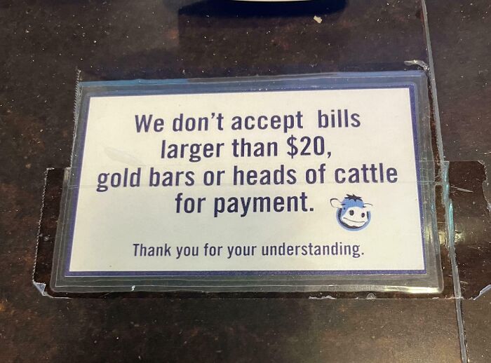 Funny and bizarre sign stating no bills larger than $20, gold bars, or heads of cattle accepted for payment.