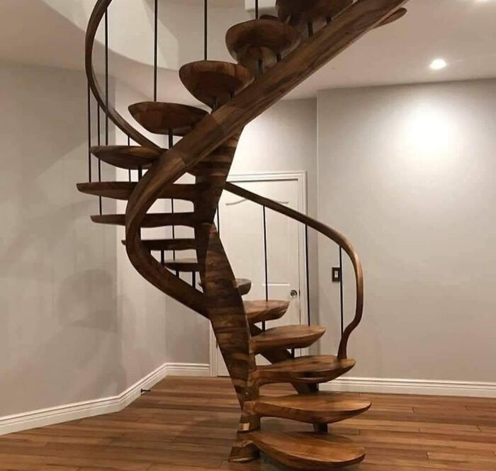 Spiral wooden staircase carved by talented woodworkers, showcasing smooth craftsmanship and elegant design in a modern interior.