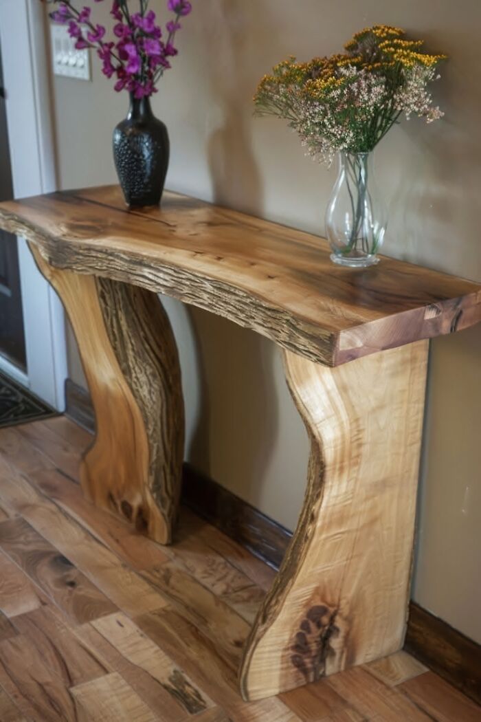 Handcrafted wooden console table with natural edge and textured legs, showcasing talented woodworking and smooth carving skills.