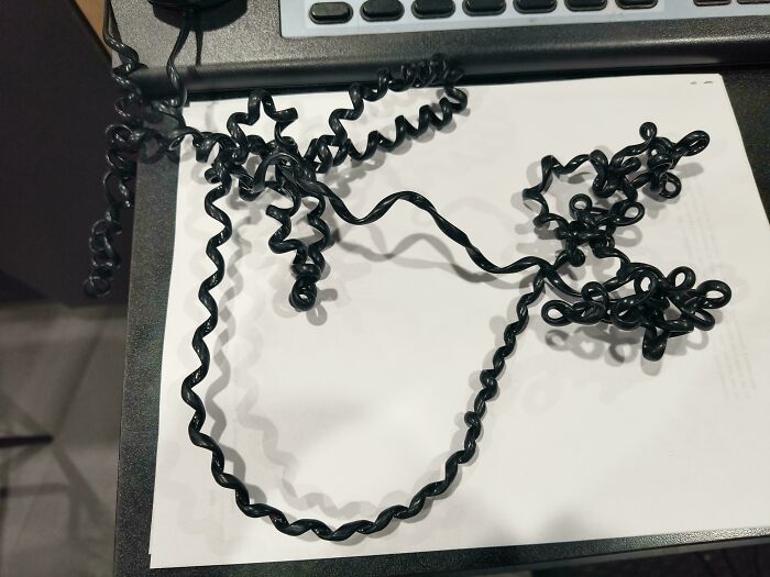Tangled black phone cord illustrating selfish and stupid behavior making it hard to work with others in office setting.