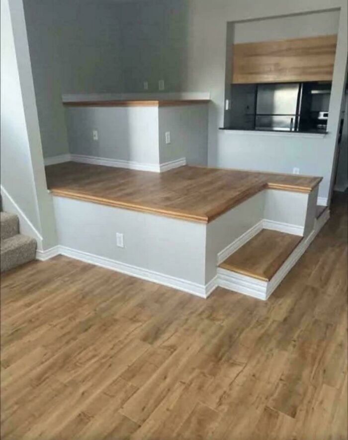 Raised wooden platform with built-in step inside a modern home, showcasing ridiculous home decor and DIY design.