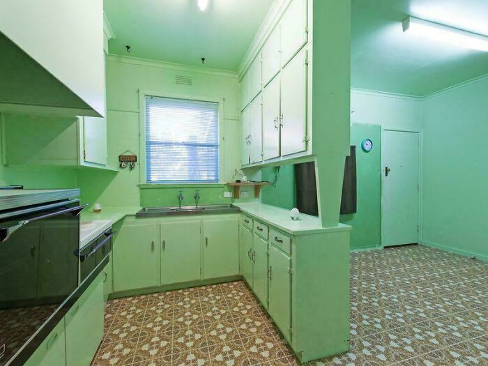 Vintage green kitchen with outdated home decor and DIY features in an old-fashioned style with floral patterned floor tiles