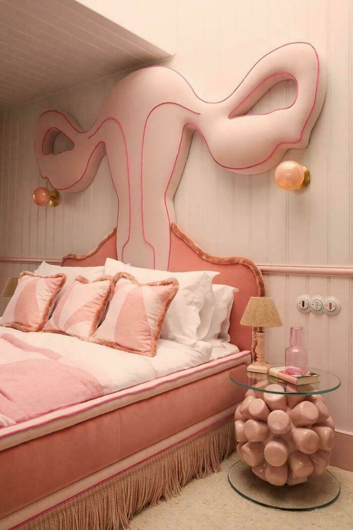 Pink whimsical bed with exaggerated headboard and quirky side table in a room showcasing ridiculous home decor and DIY ideas.
