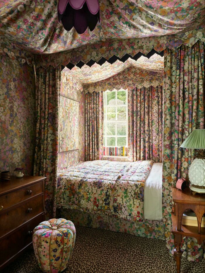 Bedroom with ridiculous home decor covered in matching floral fabric including walls, bed, and curtains for DIY style.