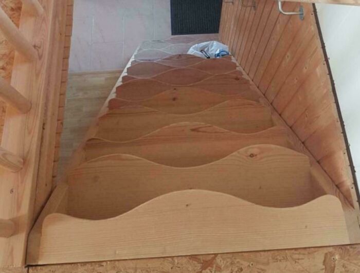 Wooden staircase with uneven, wavy steps illustrating ridiculous home decor and DIY with funny sarcastic commentary.