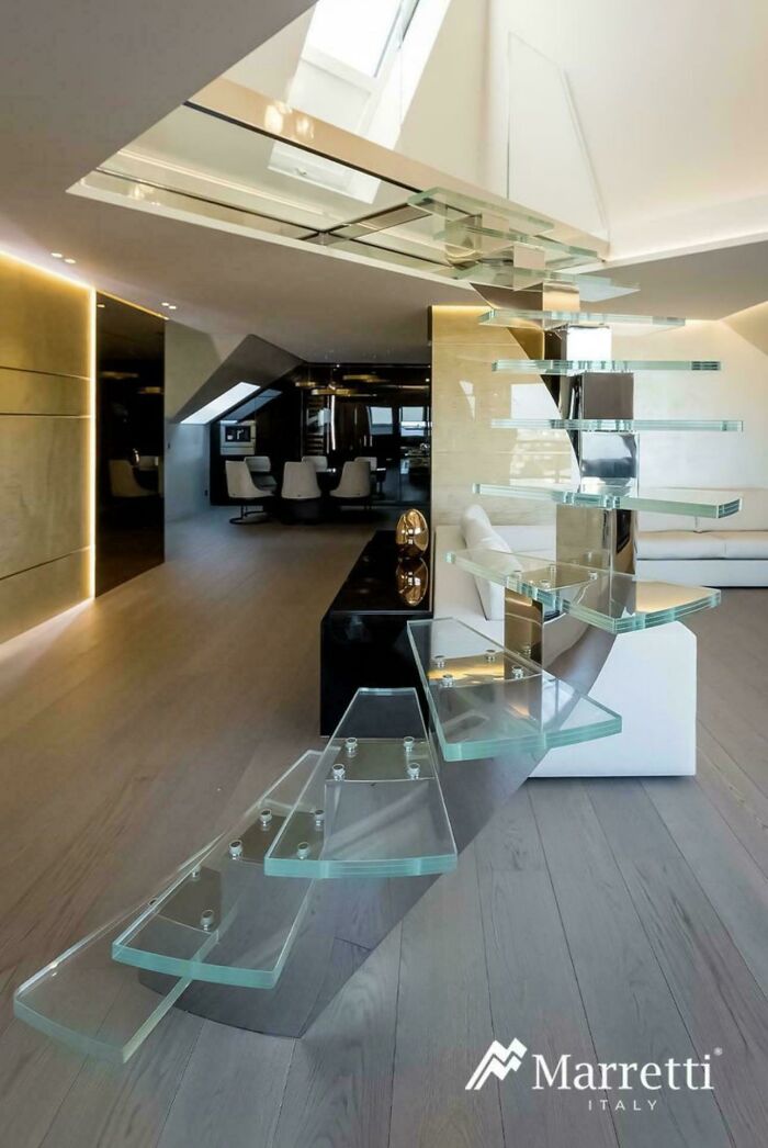 Modern home decor featuring a unique glass spiral staircase in a stylish, minimalist living space with natural lighting.