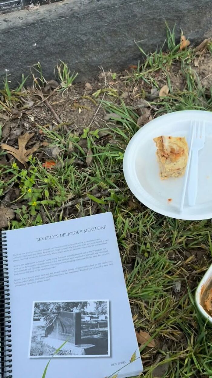 Recipe booklet and a plate with meatloaf served outdoors near a tombstone, part of woman tracking recipes etched on tombstones across USA.