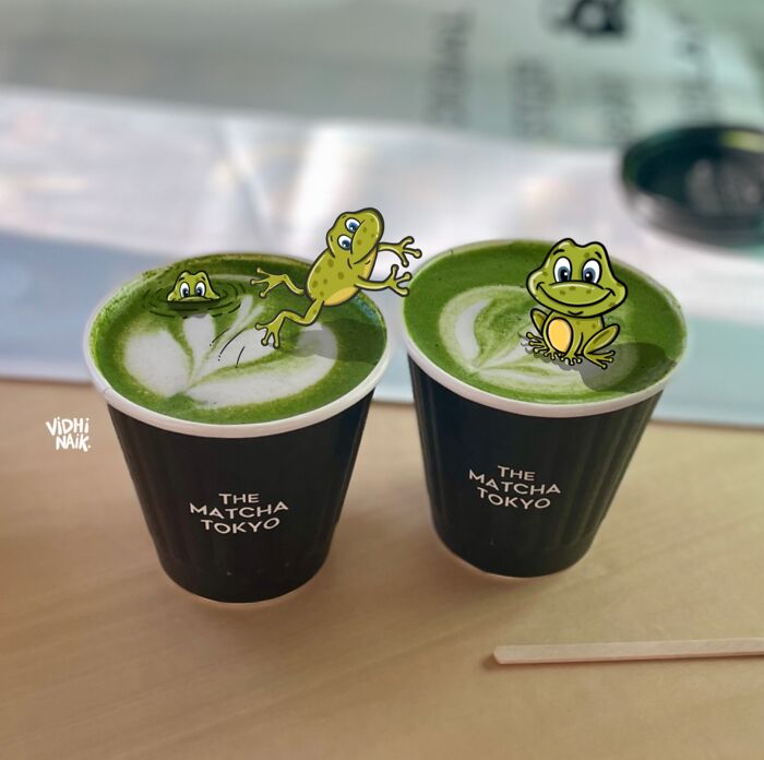 Two cups of matcha tea with cartoon frogs added, showcasing this artist turning everyday places into little cartoon scenes.