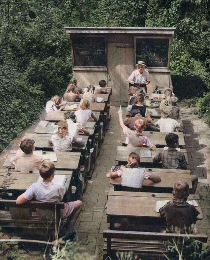 Outdoor vintage classroom with children and teacher surrounded by greenery