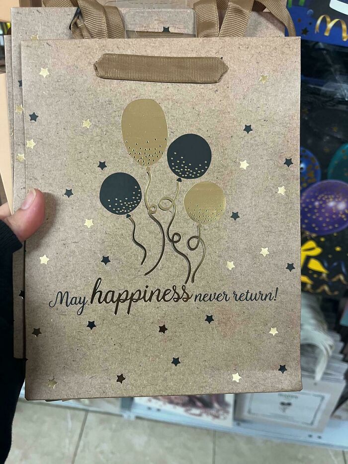 Paper gift bag with golden and black balloons and a fail message saying may happiness never return in a common sense fail example.