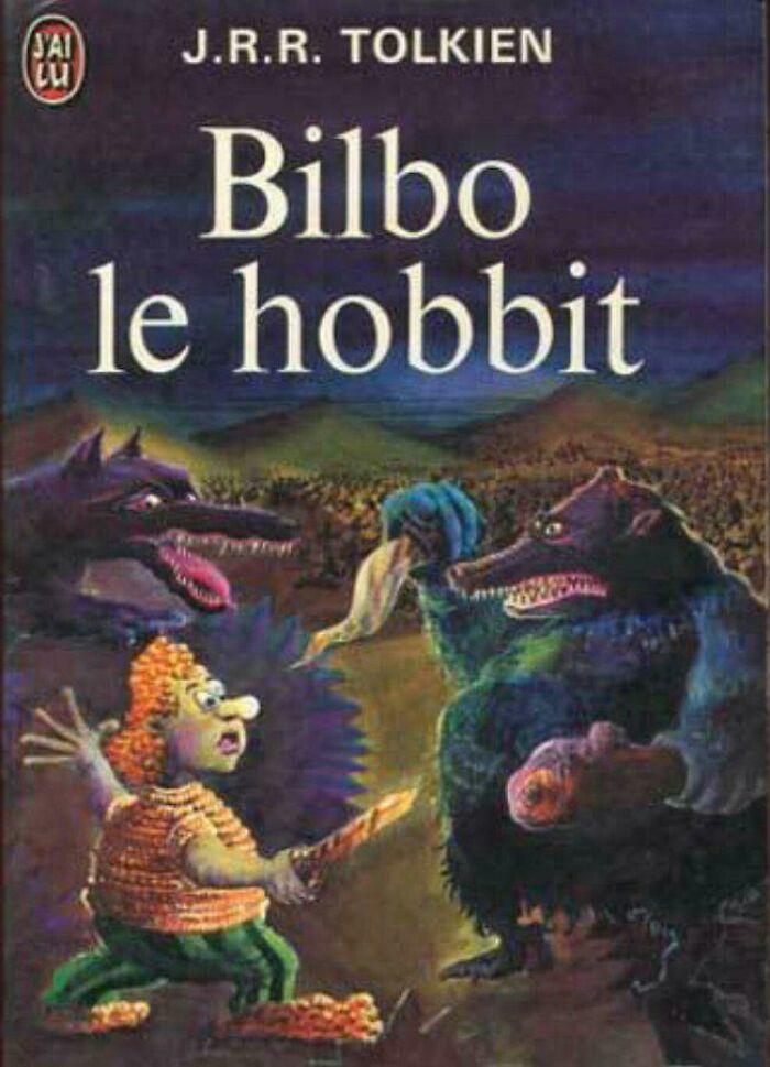 Terrible book cover of Bilbo le hobbit showing a cartoonish character facing two menacing wolf-like creatures at night.