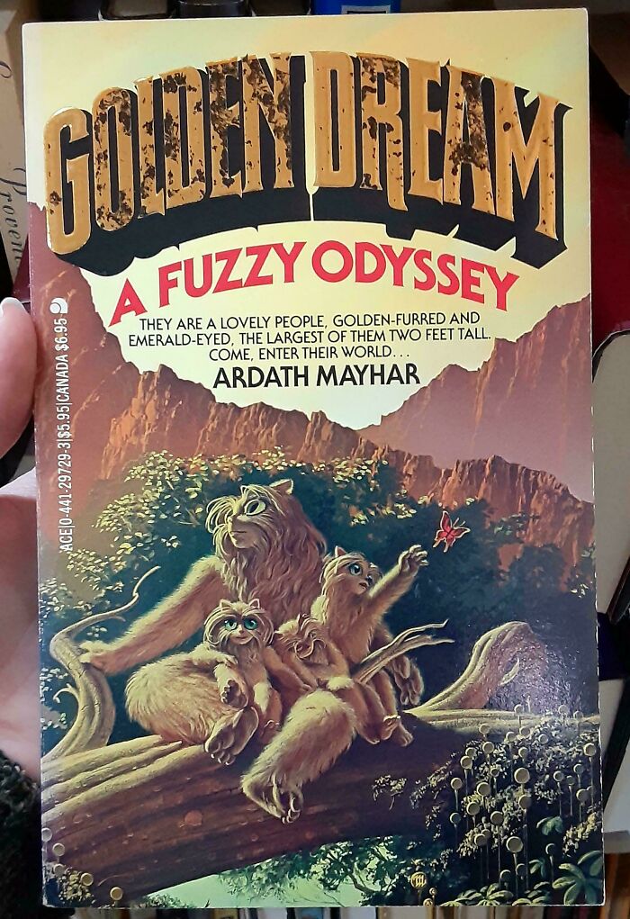 Golden Dream book cover showing furry creatures with large eyes on a log in a fantasy forest setting, a terrible book cover example.