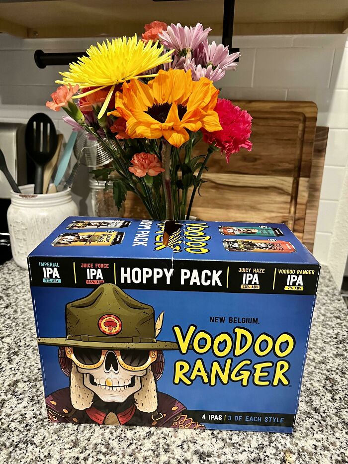Voodoo Ranger IPA beer pack on kitchen counter with colorful flowers, a funny Valentine’s Day gift idea for couples.