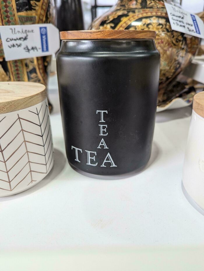 A black tea canister with vertically stacked letters spelling out TEA TEA, a hilarious design fail.