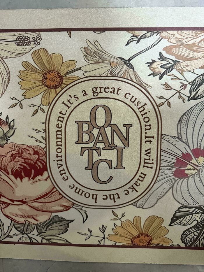 A cushion with a floral pattern and jumbled text, a design fail that should have never been approved.