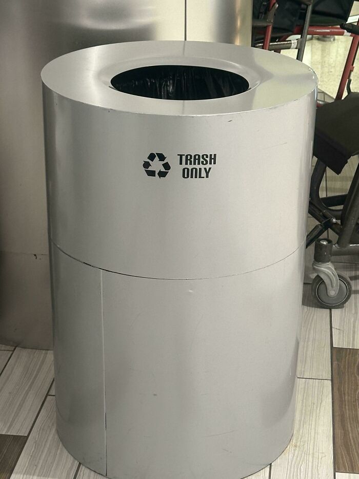 An unhinged design fail of a trash can with a recycle logo and the words TRASH ONLY written on it.