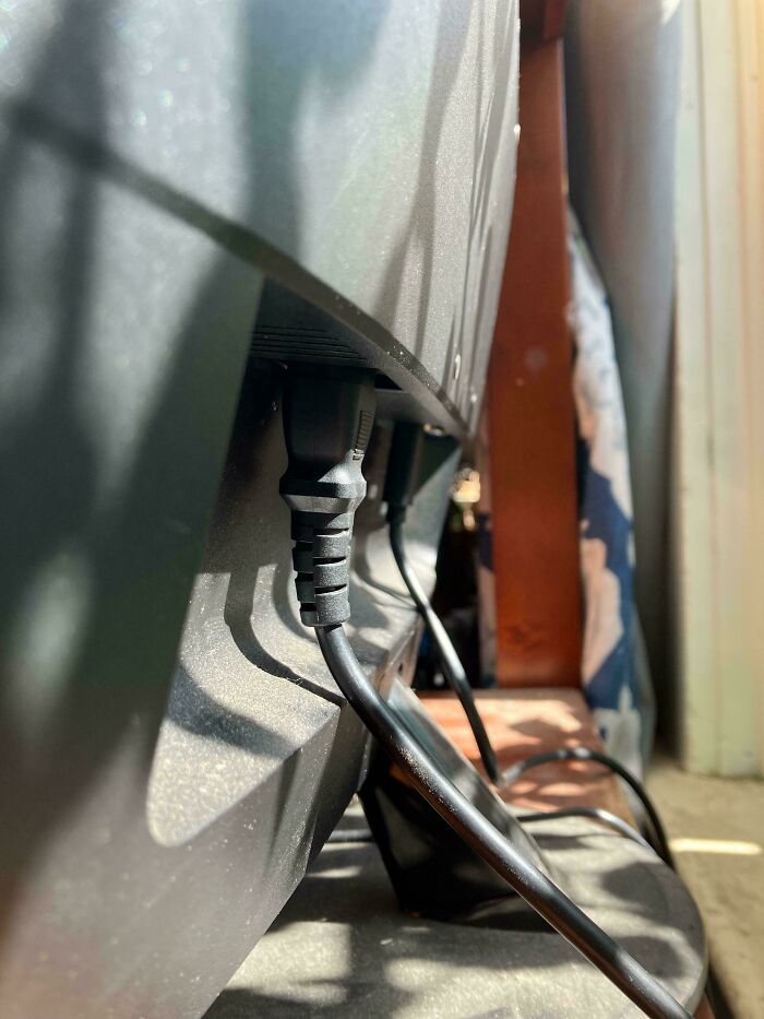 A poorly designed power outlet, resulting in a cable that bends at an extreme angle.