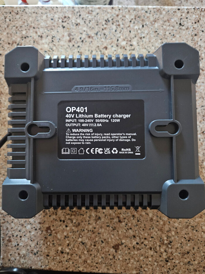 The back of a battery charger with a design fail, showing a warning to reduce risk of injury.