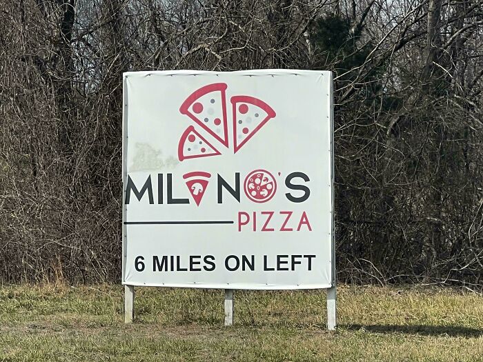 A sign for Milanos Pizza with a design fail where the pizza slices look like male anatomy.