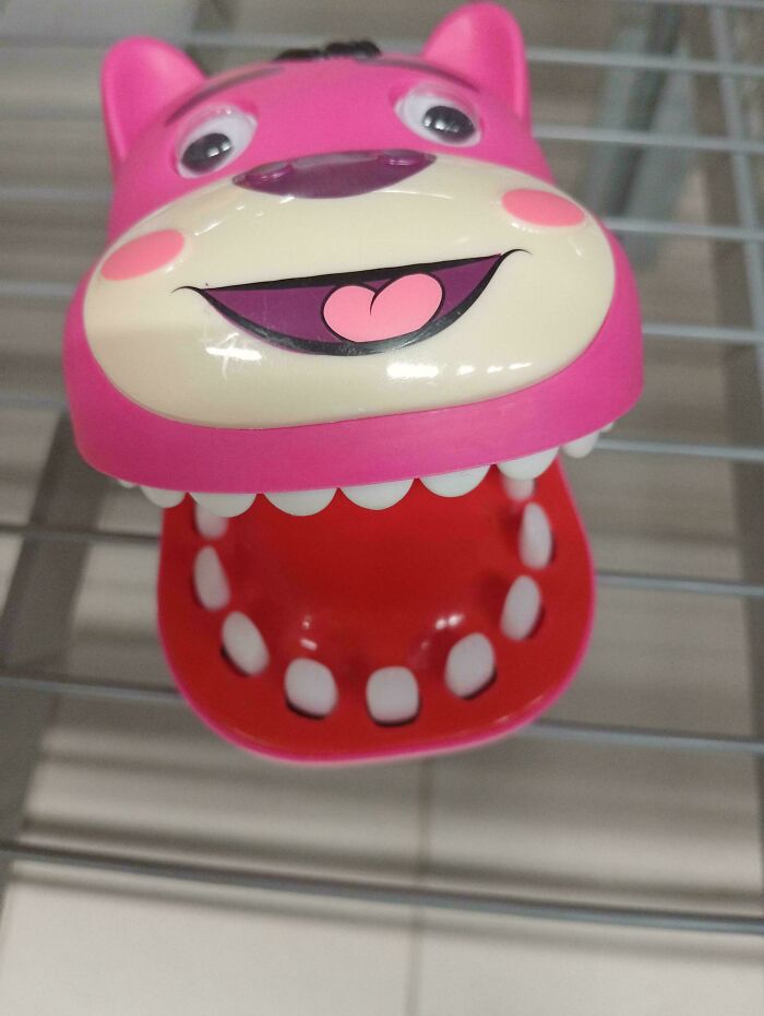 Hilariously unhinged design fail: a pink toy with a large, toothy open mouth, appearing unsettling.