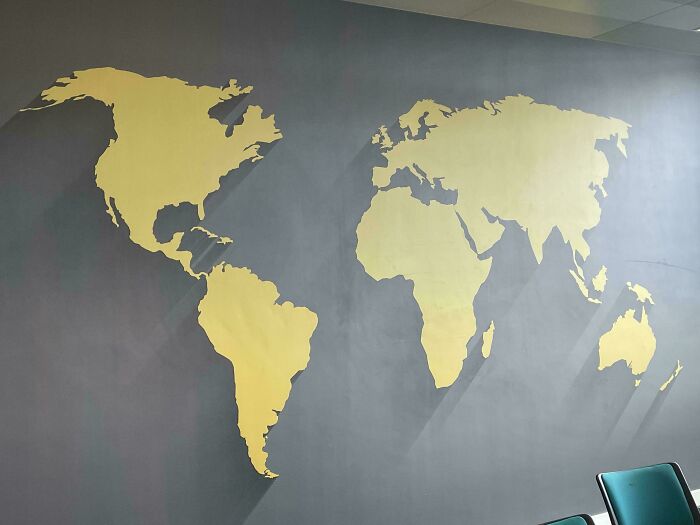 Hilariously unhinged design fails: A gold world map wall decoration with noticeable inaccuracies in country shapes.
