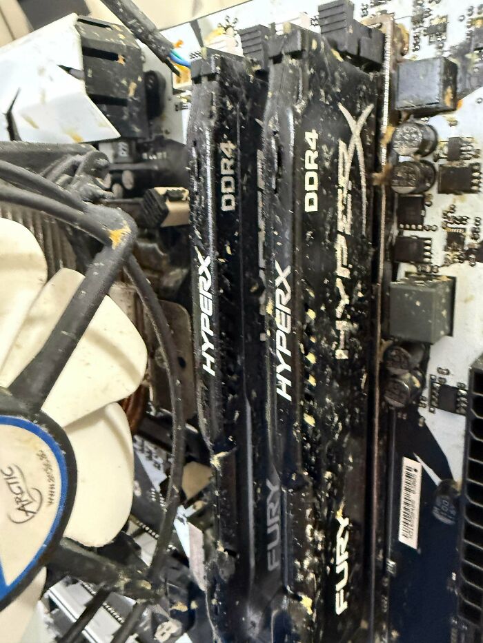 Dust-covered HyperX DDR4 RAM sticks installed on a computer motherboard showing neglected tech support hardware.