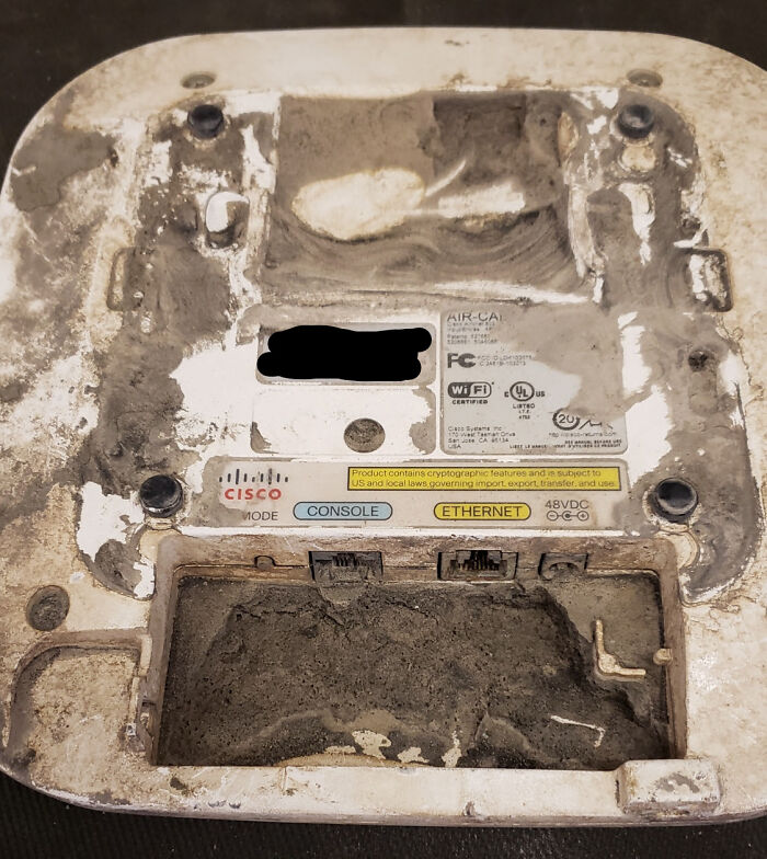 Extremely dirty and worn Cisco network device showing heavy dust and grime buildup in tech support work environment.