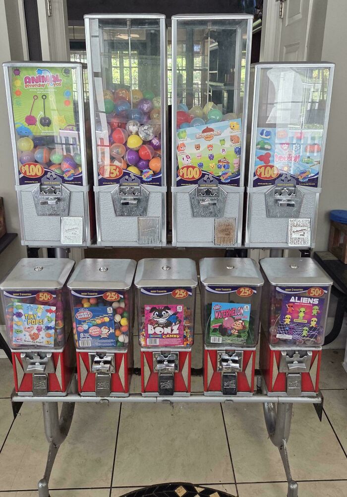 Ten gumball machines, five large and five small, filled with toys and candy, obtained via dumpster diving.