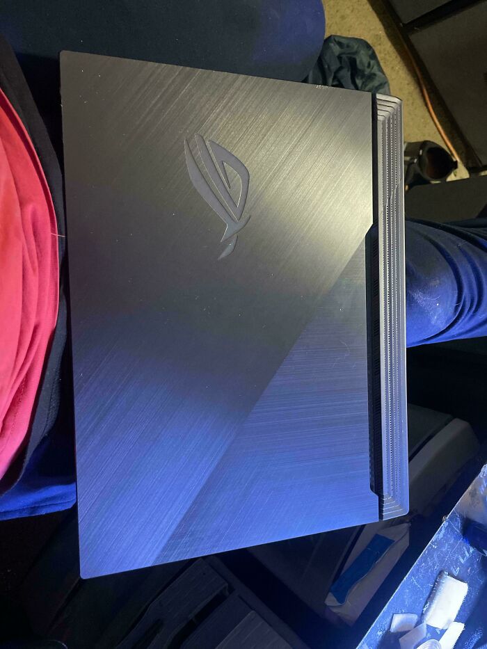 A black laptop with a glowing logo, a lucky find while dumpster diving.
