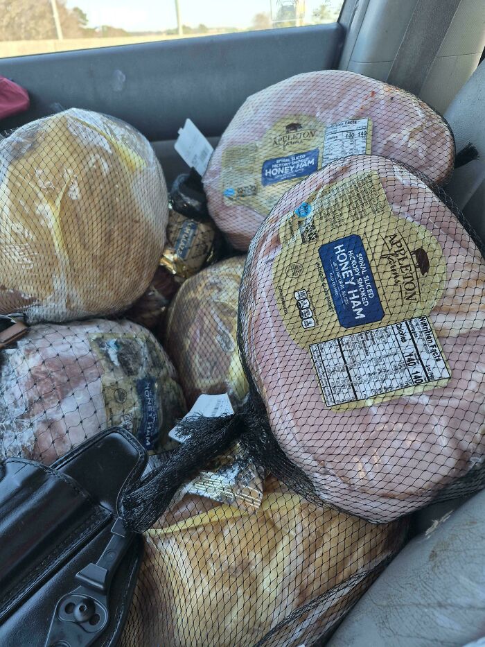 Multiple large spiral sliced honey hams in netting, excellent finds from dumpster diving.