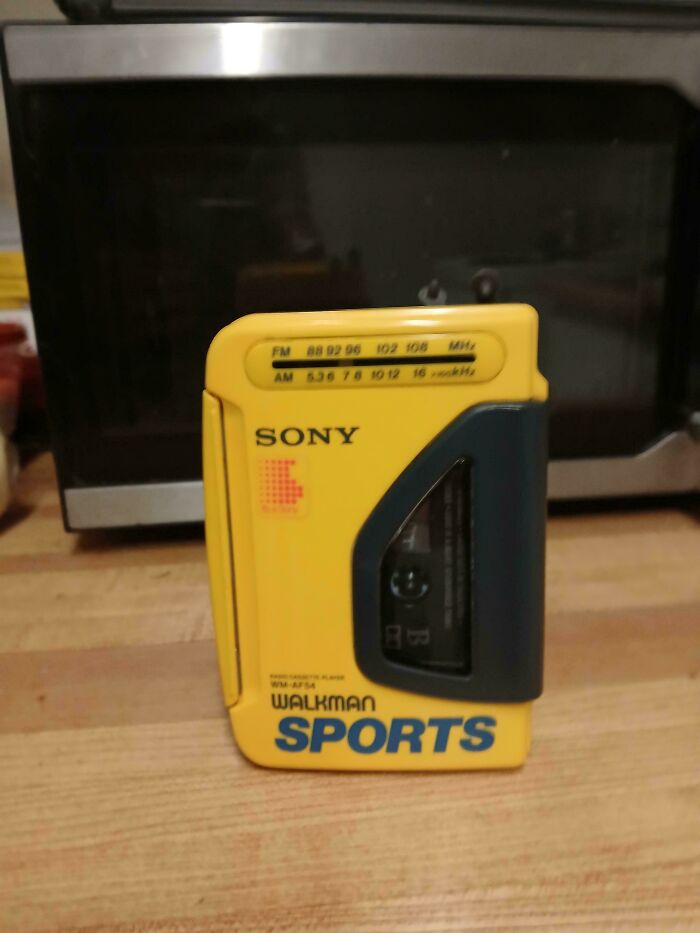 A yellow Sony Walkman Sports, a vintage electronic device, found while dumpster diving.
