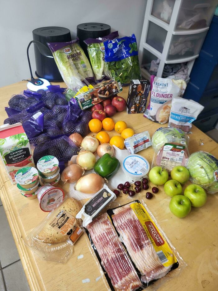 A table laden with fresh produce, meats, and dairy, all incredible finds from dumpster diving.
