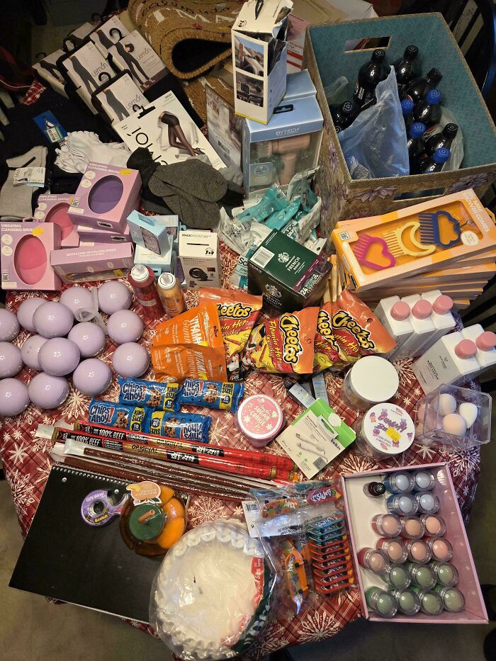 A table laden with a wide assortment of items, including snacks, toiletries, and clothing, all found while dumpster diving.