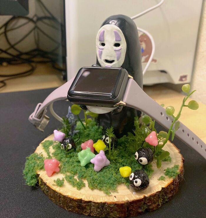 No Face figurine funny Valentine’s Day gift holder with colorful stars and plants on wooden base.