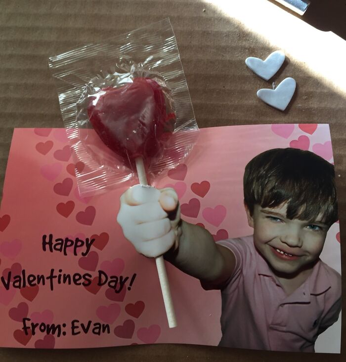 Child holding a heart-shaped lollipop with a Valentine’s Day card, illustrating funny Valentine’s Day gifts that bring laughter.