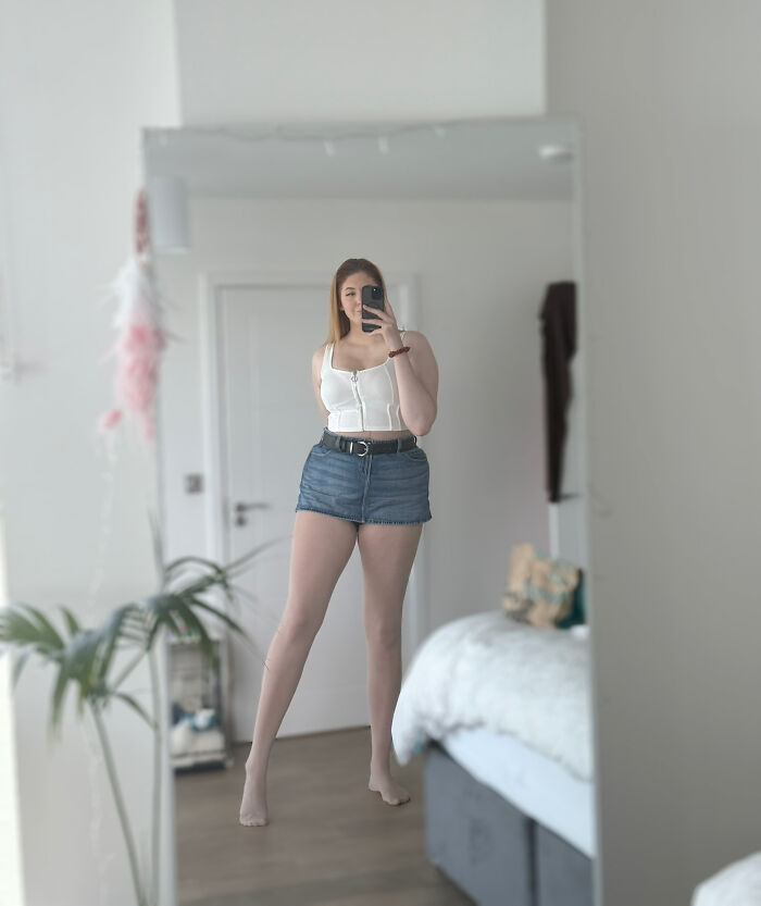 Mildly interesting pictures of a young woman taking a selfie in a mirror, showing off her long legs.