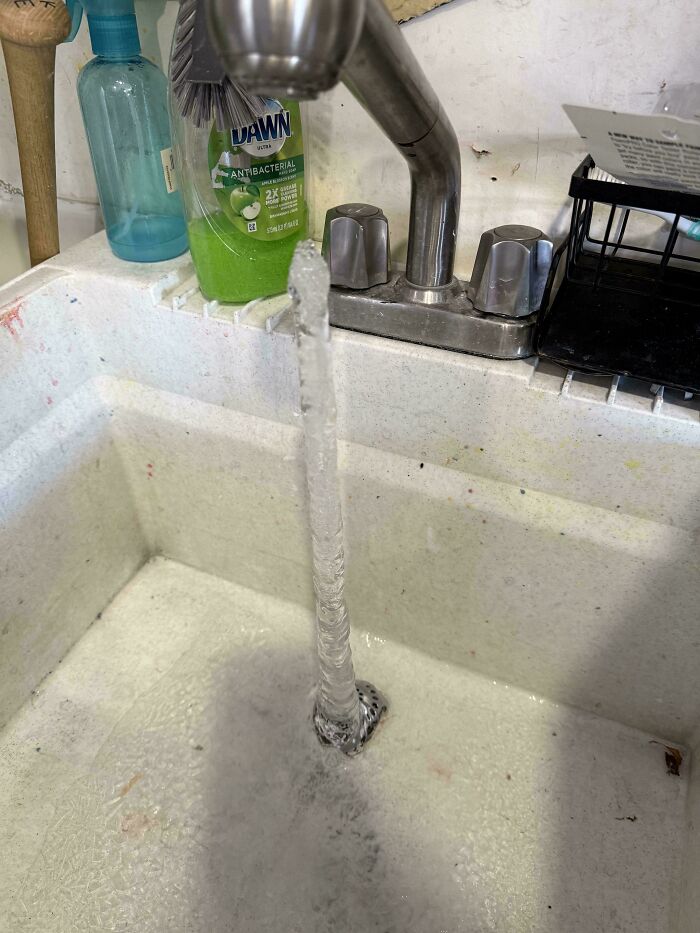 Mildly interesting pictures: A strong, rope-like stream of water flows directly down a utility sink drain.