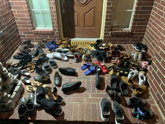 Many pairs of shoes arranged on a brick porch under yellow light, illustrating a unique devil sunrise moment.