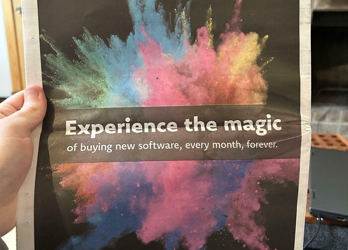 Hand holding a colorful consumerism ad promoting buying new software every month, illustrating bad consumerism effects.