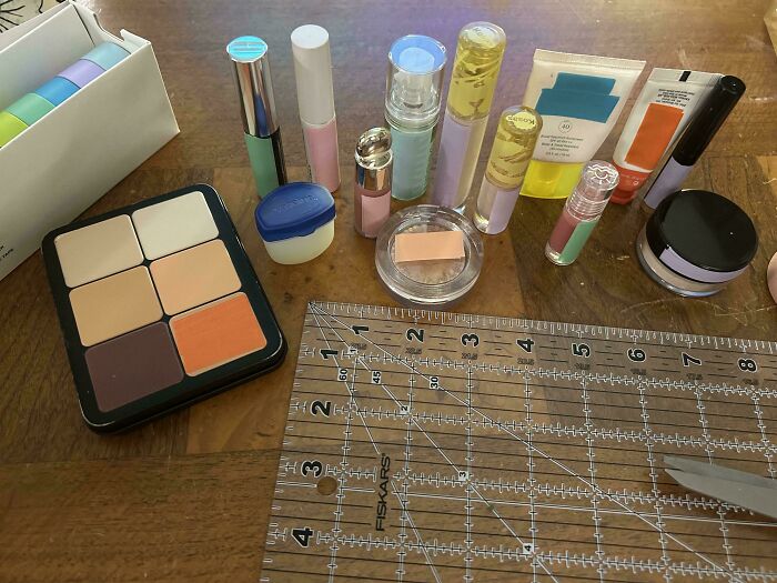 Assortment of cosmetic products and tools on wooden surface illustrating excess consumerism impact.