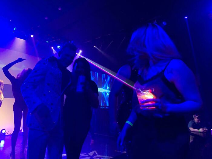 People in a nightclub with colorful lighting, capturing a photo that ended up way better than expected.