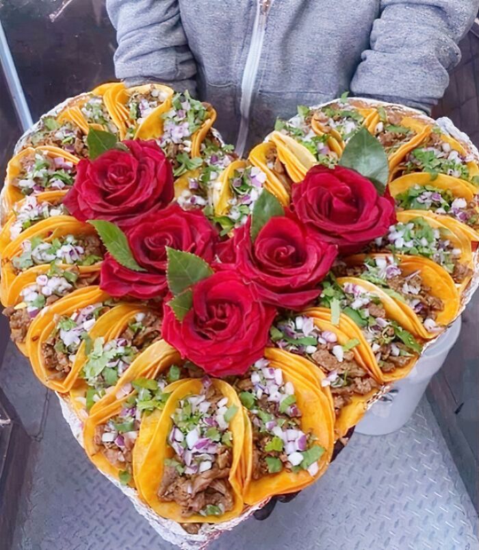Heart-shaped bouquet of tacos with red roses, a funny Valentine’s Day gift combining food and love humor.
