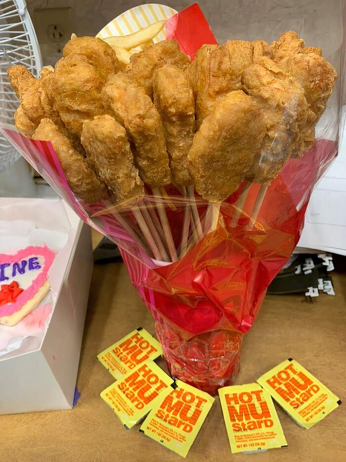 Bouquet of fried chicken on sticks wrapped in red paper with hot mustard packets, a funny Valentine’s Day gift idea.