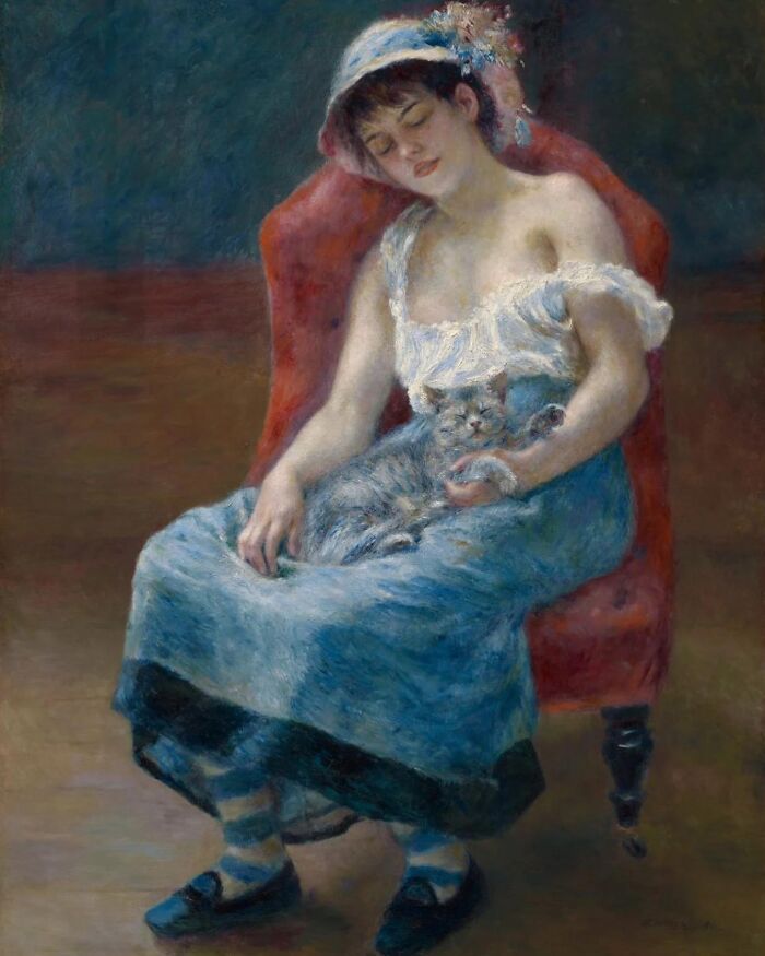 Woman in vintage dress sitting on a red chair holding a cat, a classic example of cat-themed artworks throughout history.